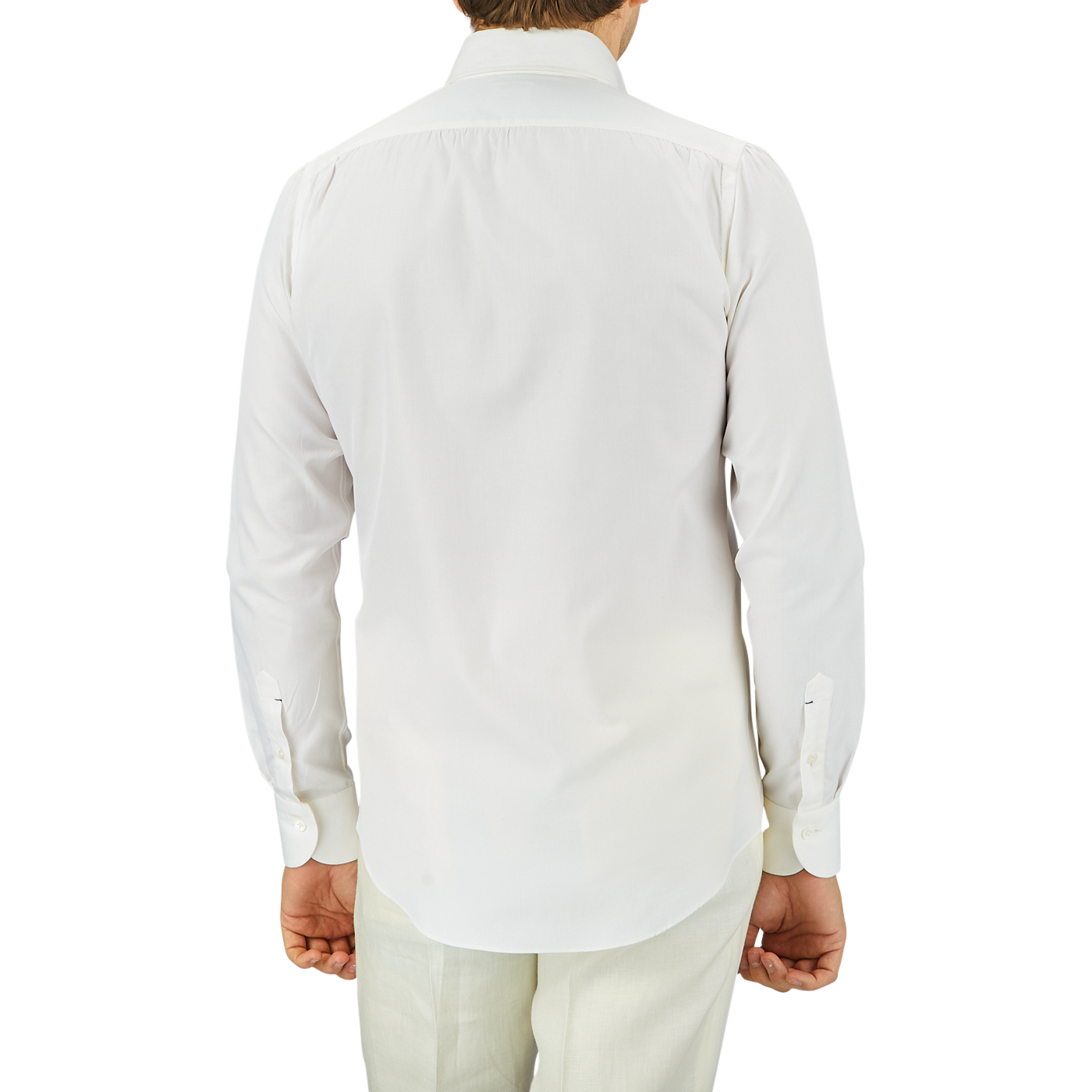 Rear view of a man wearing an Off White Cotton Twill BD Slim Shirt by Mazzarelli and light green pants, standing against a gray background.