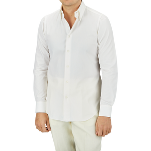 A man wearing a crisp Mazzarelli Off White Cotton Twill BD Slim Shirt and cream pants against a grey background.
