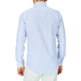Man standing with his back to the camera, wearing a Mazzarelli White Blue Bengal Striped BD Slim Shirt featuring a soft button-down collar, paired with light-colored pants.