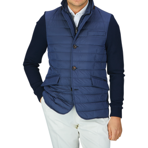 A man wearing a Moorer Ocean Blue Nylon Knitted Sleeve Jacket and white pants.