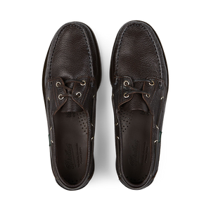 A pair of dark brown grained calf leather Paraboot boat shoes on a black background.