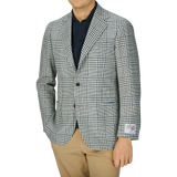 A man wearing a Ring Jacket Blue Green Glen Check Balloon Wool blazer, beige pants, and a dark shirt, photographed from neck to waist against a grey background.
