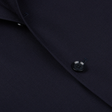 Close-up of a Ring Jacket Navy Blue Wool Balloon Travel Blazer featuring a detailed view of a button and fabric texture.