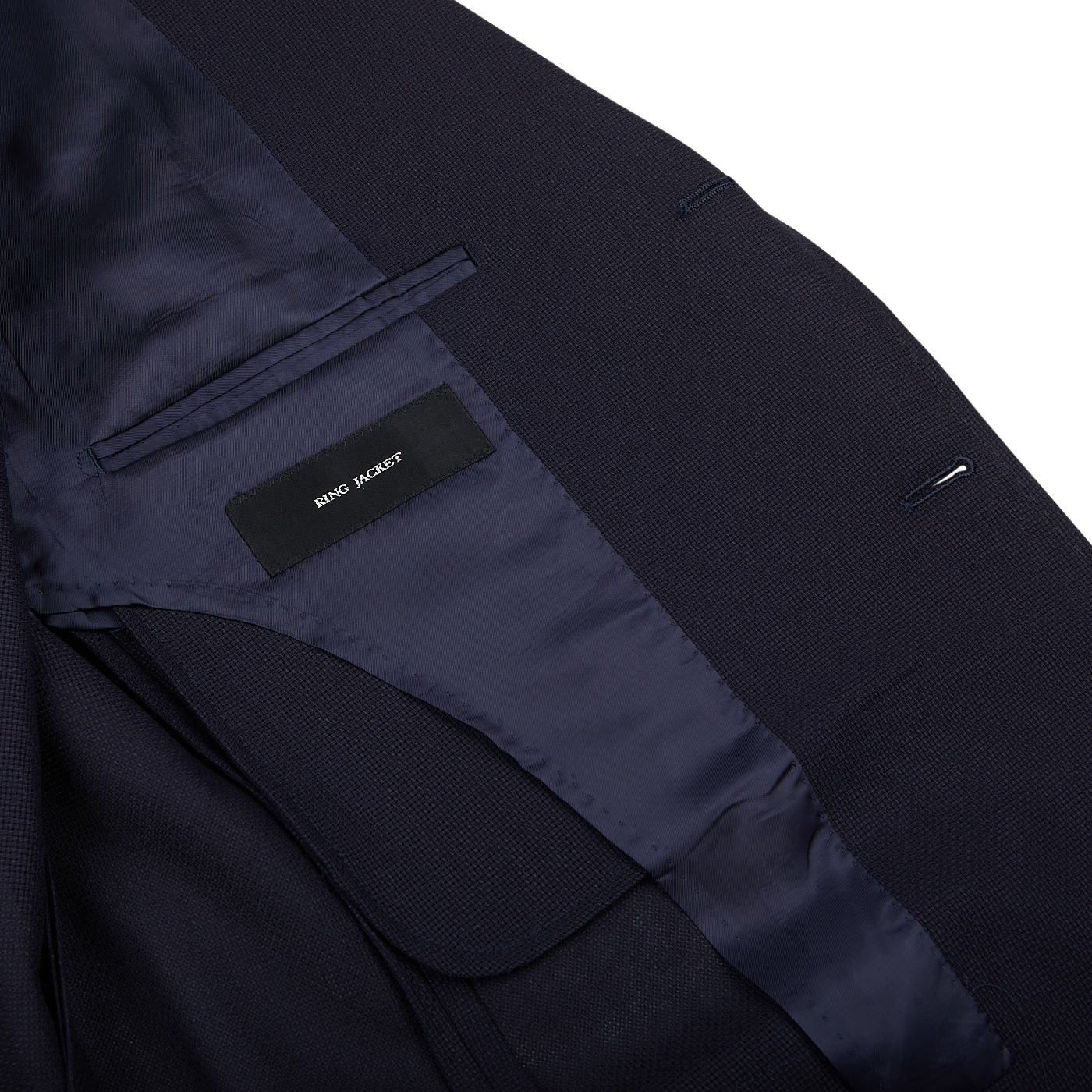 Close-up of a Navy Blue Wool Balloon Travel Blazer with a "Ring Jacket" brand label visible inside.