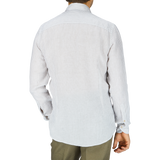 The man is wearing a white Light Grey Striped Linen Stenströms shirt and khaki pants, seen from the back.