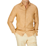 A man in a Stenströms Tobacco Brown Linen Fitted Body Shirt and tan pants, the perfect summer essential outfit.