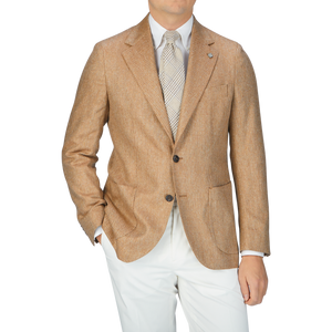 A man wearing a Studio 73 Camel Brown Herringbone Pure Silk Blazer and silk white pants.