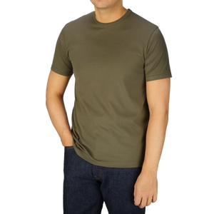 A man in a Sunspel Khaki Green Classic Cotton T-Shirt and jeans made of cotton.