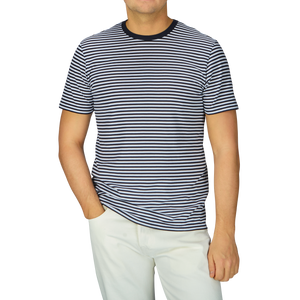 A man wearing a comfortable Navy White Striped Classic Cotton T-Shirt by Sunspel and white pants.