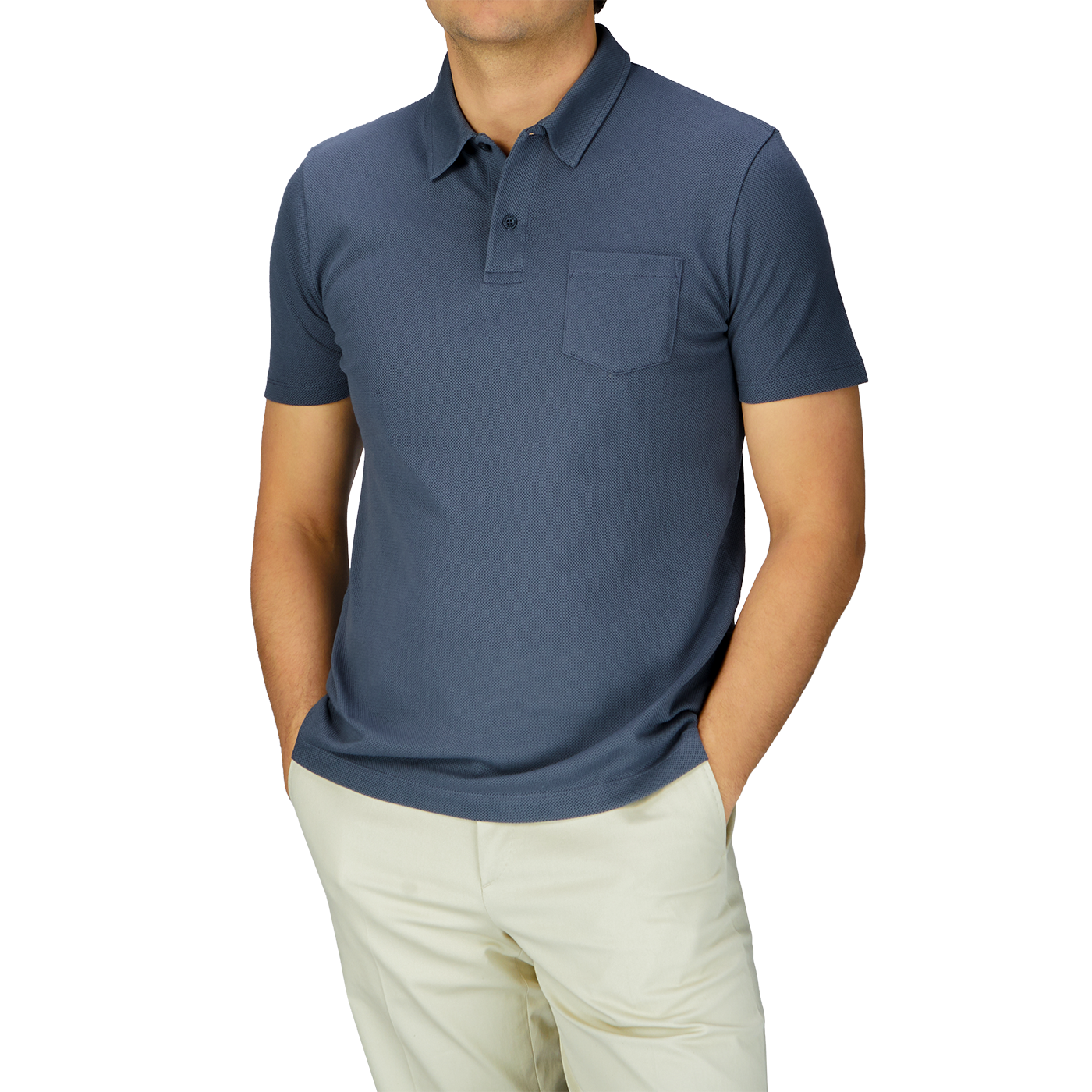 James Bond sports a classic Slate Blue Cotton Riviera Polo Shirt by Sunspel, paired with khaki pants.