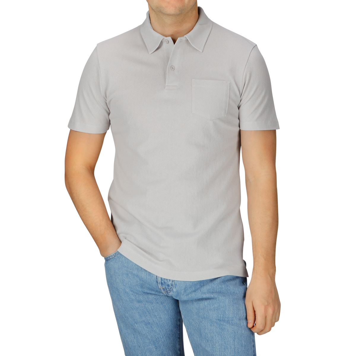 A man in a Smoke Grey Cotton Riviera Polo Shirt by Sunspel and jeans.