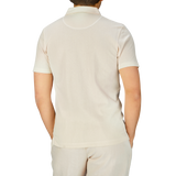 The man, wearing a white Undyed Cotton Riviera Polo Shirt, resembles James Bond in the stylish Sunspel design.