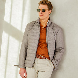 A man is leaning against a wall wearing a Herno Taupe Beige Silk Cashmere Water-Repellent Jacket.