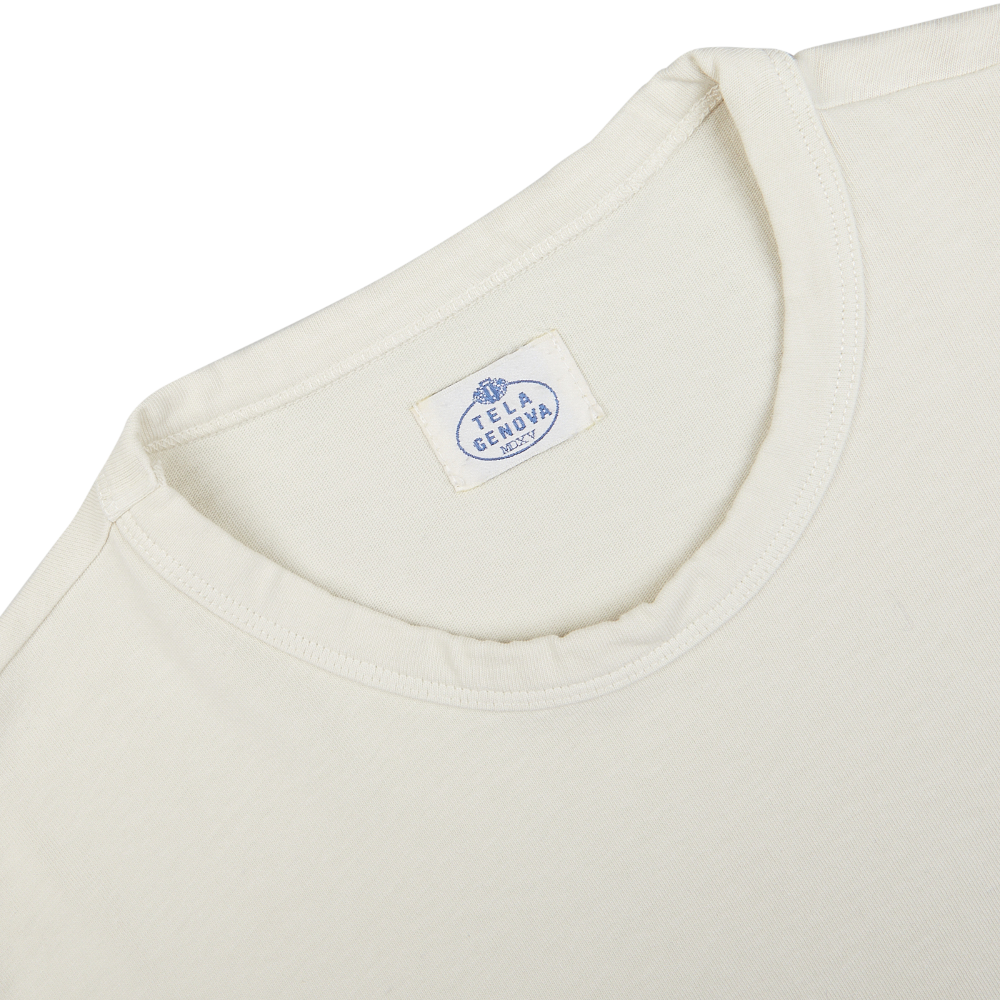 Close-up of a cream-colored Tela Genova Off-White Heavy Organic Cotton LS T-Shirt's neckline showing the Tela Genova brand label.