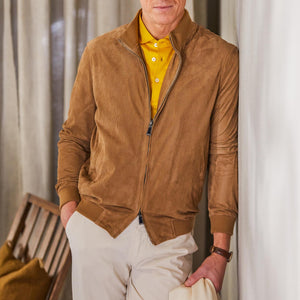 A man in a Manto Tobacco Brown Perforated Suede Leather Blouson jacket leaning against a wall.