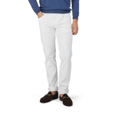 A man in Tramarossa's White Super Stretch Michelangelo Jeans and a blue sweater.