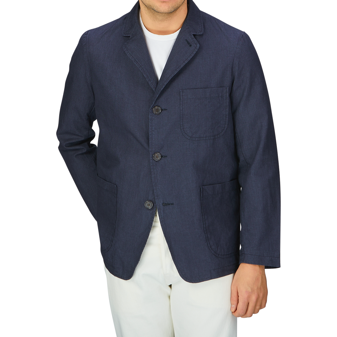 A man wearing a Universal Works Navy Puppytooth Linen Cotton 3-Button Jacket and white pants.