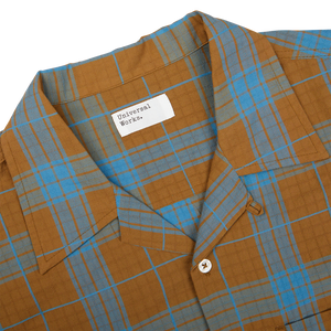 A brown and blue plaid, cotton camp collar shirt from Universal Works.