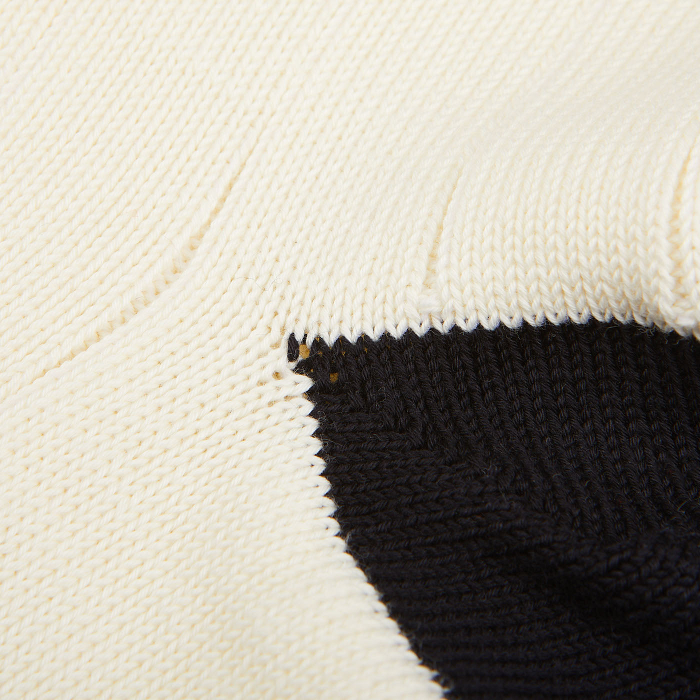 Close-up of a William Lockie cream white cotton contrast cable-knit sock with a small, visible defect on the seam.