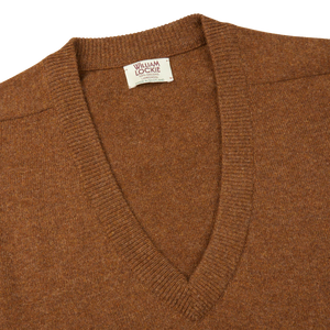 A William Lockie Kestrel Brown Deep V-Neck Lambswool Sweater with a label on it.