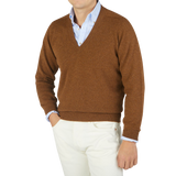 A man wearing a William Lockie Kestrel Brown Deep V-Neck Lambswool Sweater.