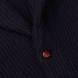 A close up of a William Lockie Navy Blue Cashmere Shawl Collar Cardigan with a wooden button.
