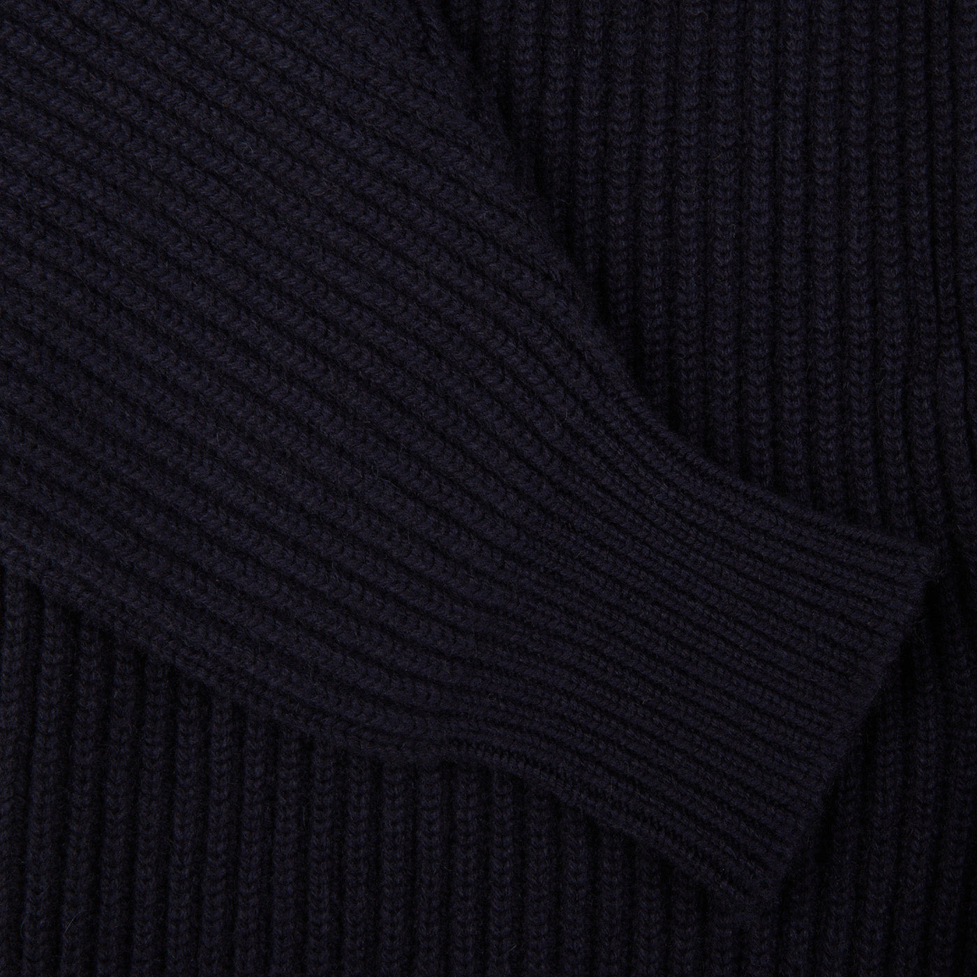 A close up of a William Lockie Navy Blue Cashmere Shawl Collar Cardigan with leather buttons.