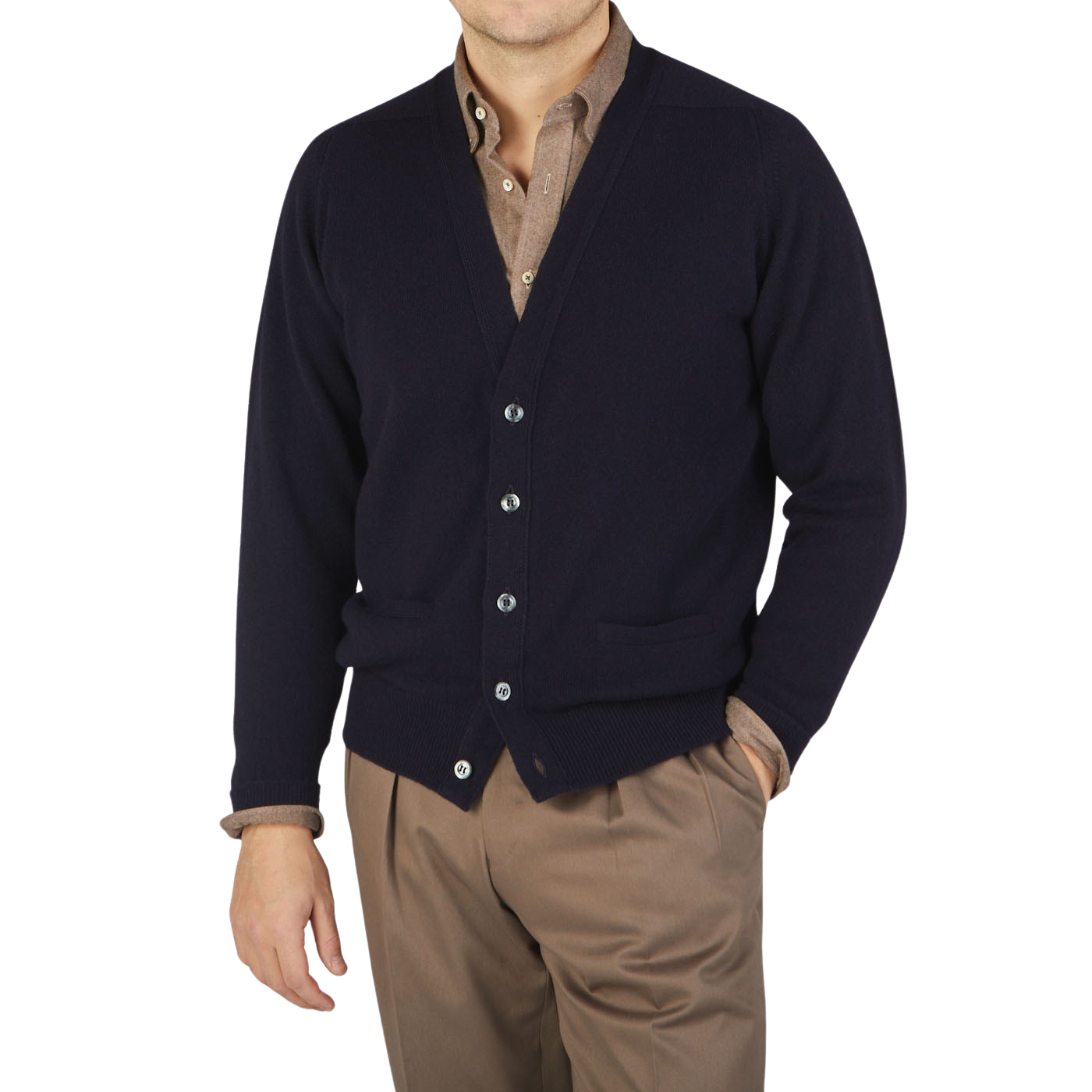 A man wearing a William Lockie Navy Lambswool Saddle Shoulder Cardigan sweater and tan pants made from Scottish lambswool.