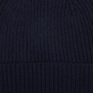 A close up of a William Lockie Nero Navy Cashmere Fine Ribbed Beanie.