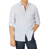 Man wearing a Xacus beige striped washed linen legacy shirt and dark jeans, with the shirt partially untucked.