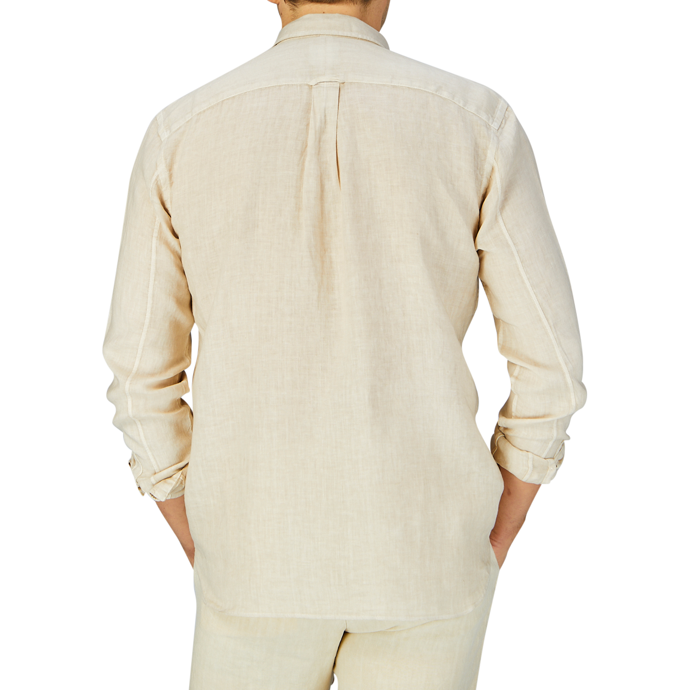A person seen from behind wearing a Light Beige Washed Linen Legacy Shirt by Xacus, with a cut-away collar, long sleeves, and pleat detail.
