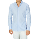 Man wearing a Xacus Light Blue Cotton Twill Tailor Fit Shirt and white pants.