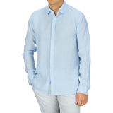 Man wearing a Xacus Light Blue Washed Linen Legacy Shirt in a regular fit and white trousers.