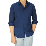 A man wearing a casual Xacus Navy Blue Cotton Twill Tailor Fit Shirt and light gray pants.