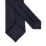 A Navy Blue 7-Fold Wool Hopsack Tie by Dreaming Of Monday with an elegant drape on a white background.