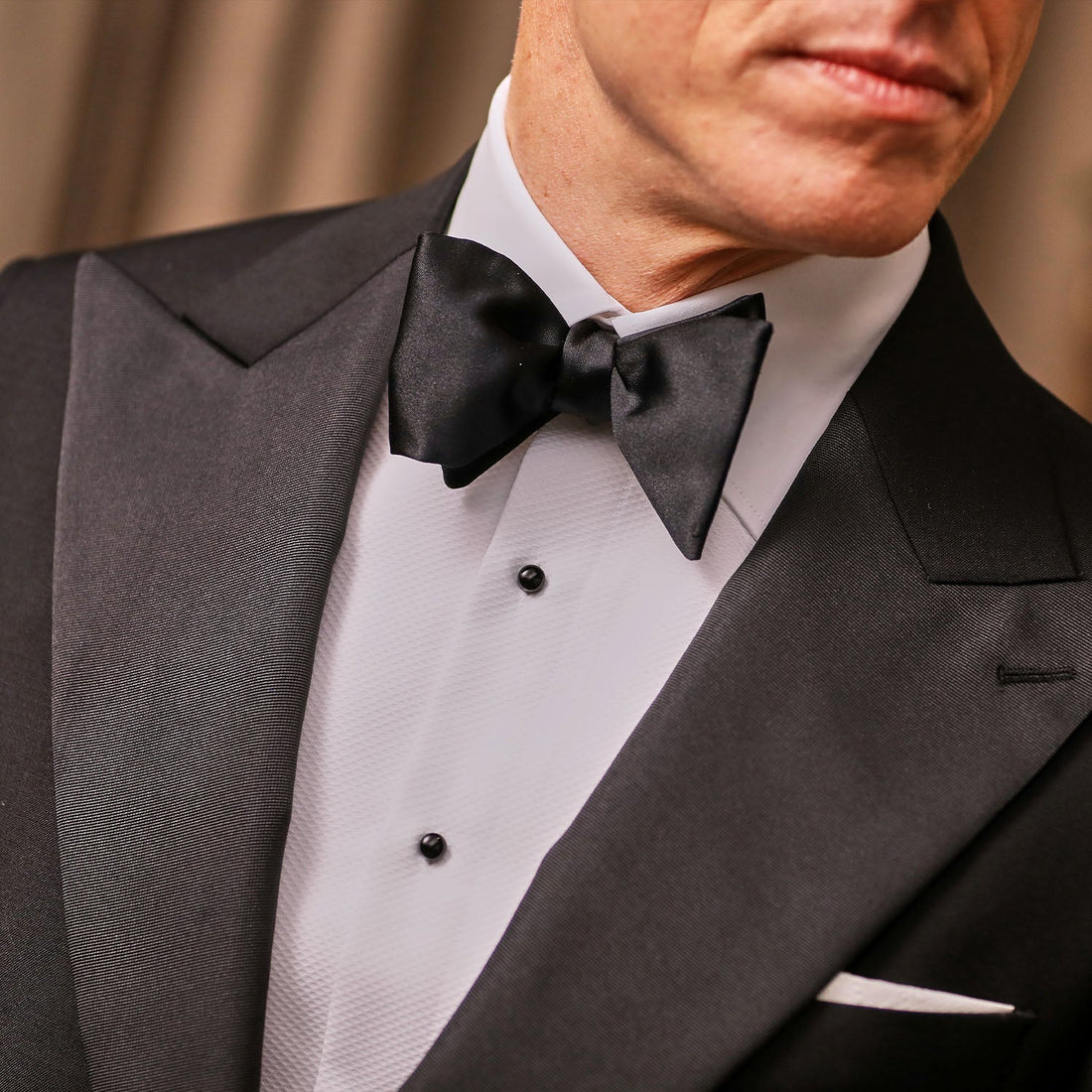 A man in a green velvet tuxedo wearing a bow tie.