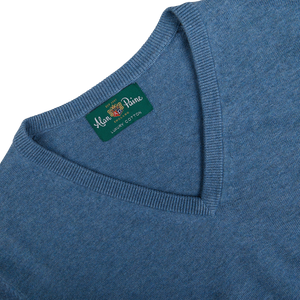 Close-up of a blue garment label reading "Alan Paine, 100% luxury cotton cashmere.