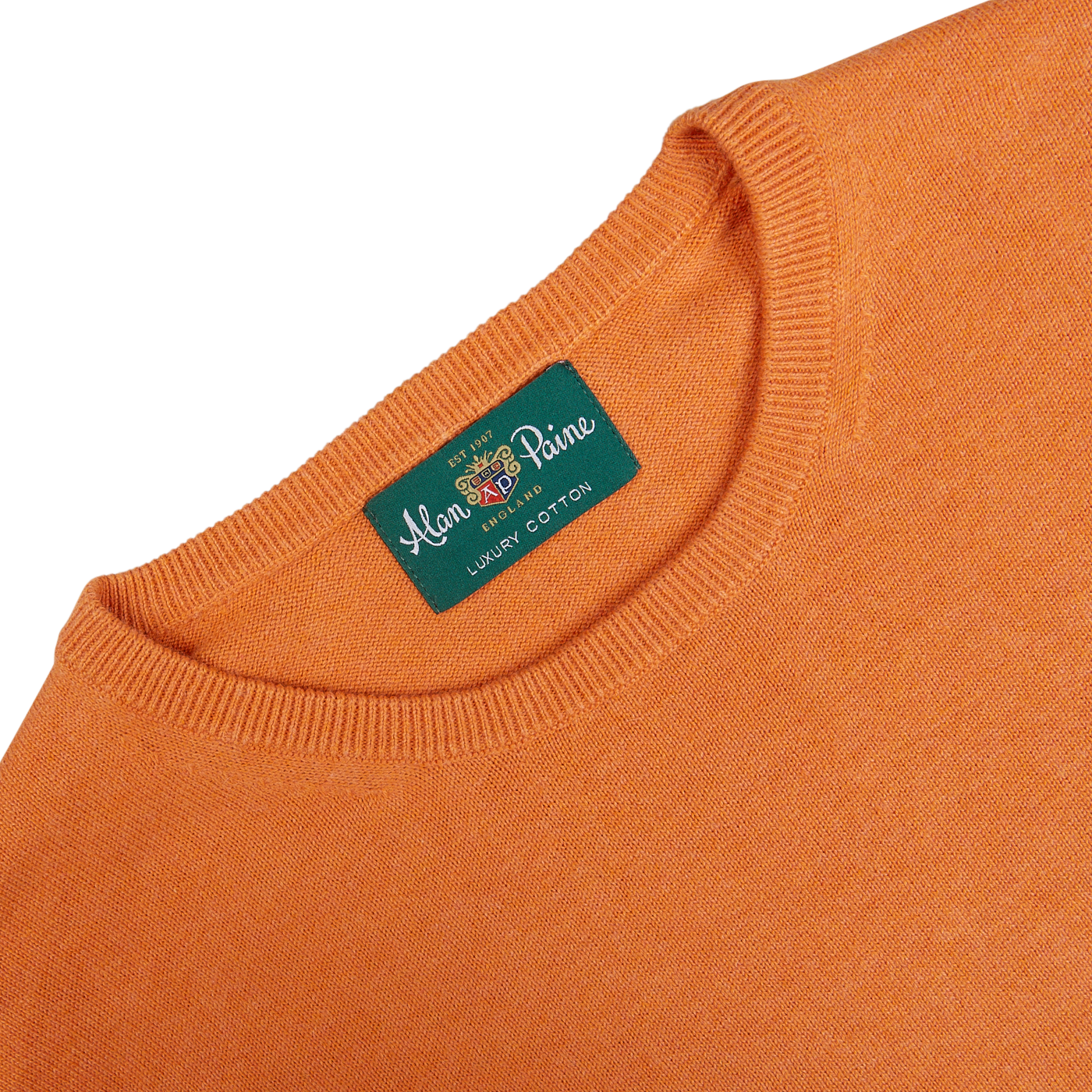 Close-up of the label on a Blazing Orange Luxury Cotton Crewneck by Alan Paine.