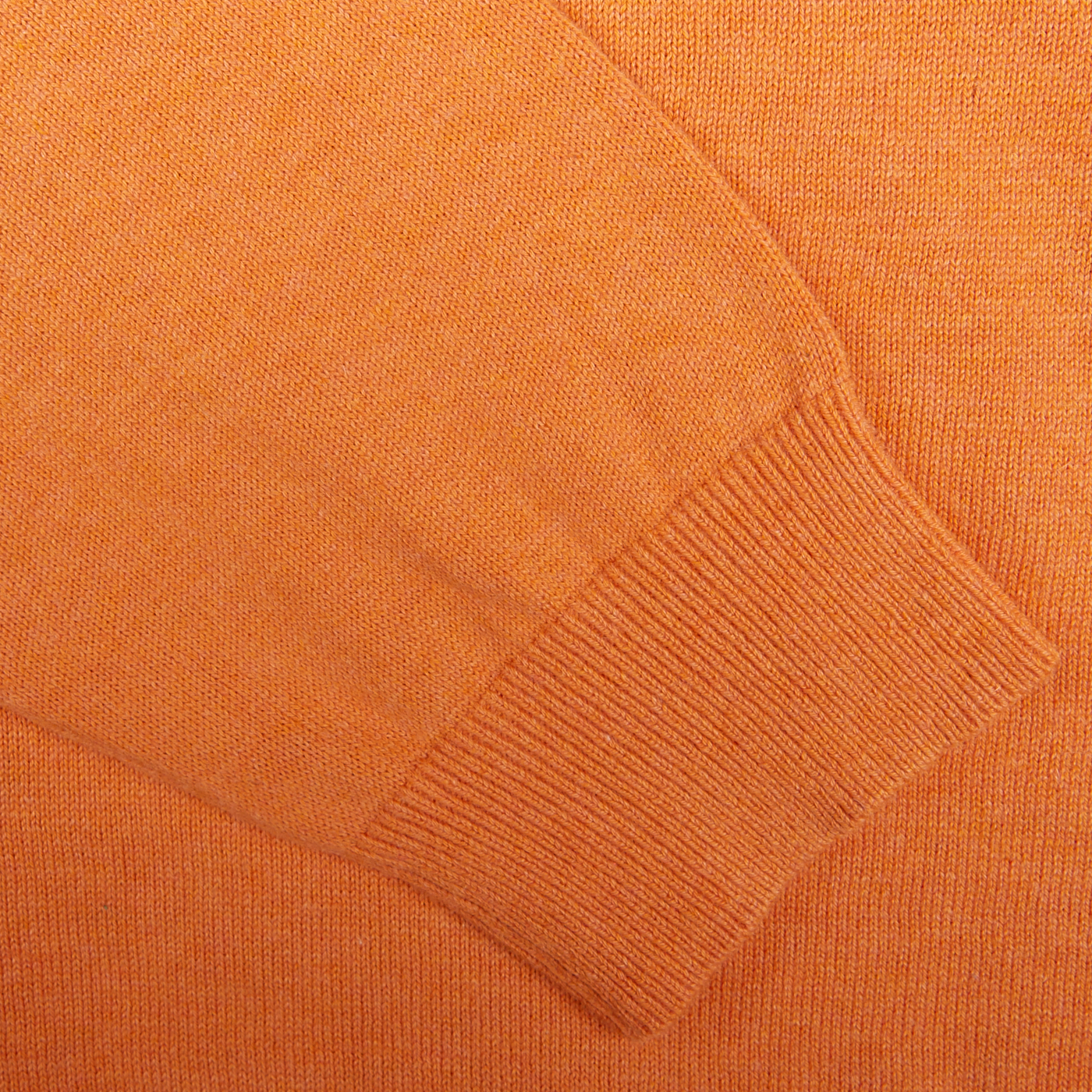 Close-up of a Blazing Orange Luxury Cotton Crewneck fabric, knitted in cotton mixed with cashmere, with ribbed cuff detail by Alan Paine.