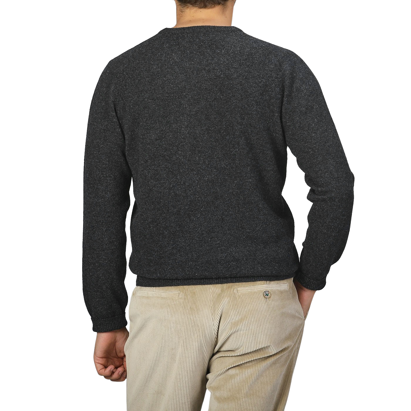 An individual is depicted from behind, dressed in the Charcoal Grey Lambswool Crew Neck by Alan Paine, paired with light-colored corduroy pants, against a plain backdrop.