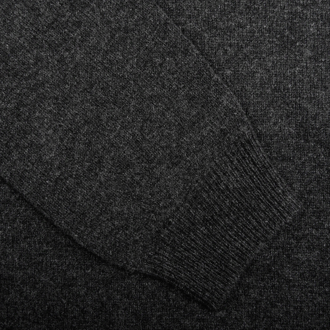 Close-up of a Charcoal Grey Lambswool Crew Neck by Alan Paine, highlighting the ribbed cuff detail on the luxurious Australian lambswool knitted sweater sleeve.