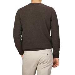 A person is shown from the back, wearing the Cocoa Brown Lambswool Crew Neck by Alan Paine and light beige pants.