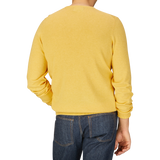 Rear view of a person wearing an Alan Paine Corn Yellow Luxury Cotton Crewneck and blue jeans.