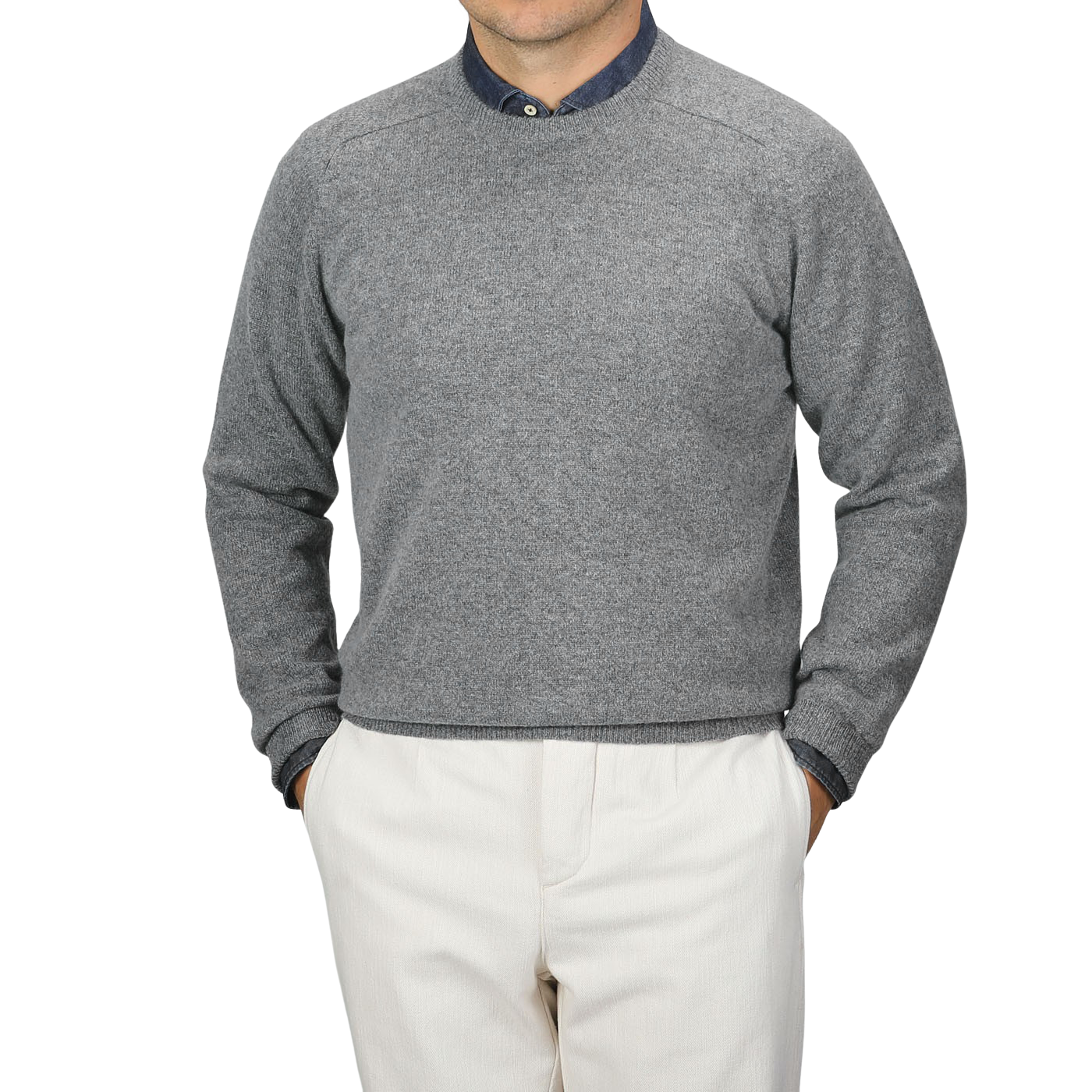 A person wearing an Alan Paine Grey Melange Lambswool Crew Neck over a blue collared shirt and beige pants, standing with hands in pockets against a plain background.