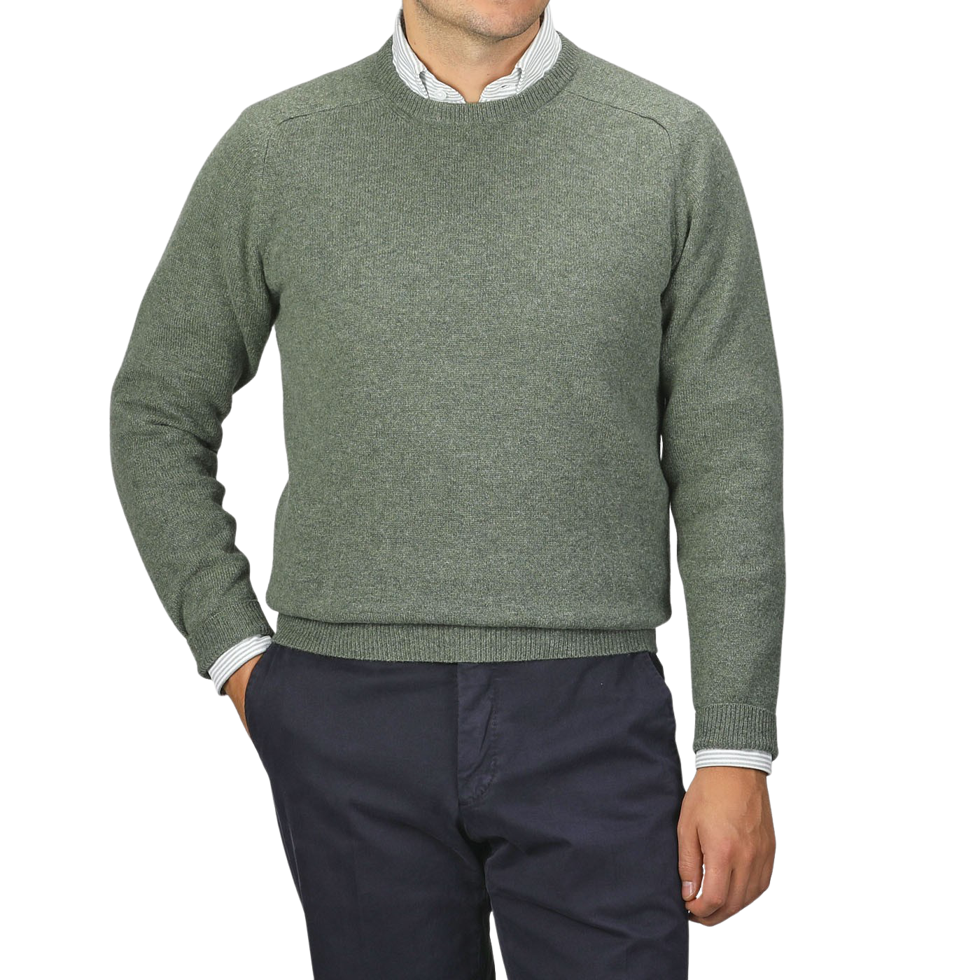 A man wearing an Alan Paine Landscape Green Lambswool Crew Neck sweater over a white collared shirt and dark blue pants stands against a plain gray background.