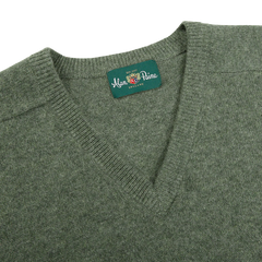 A close-up of the Landscape Green Lambswool V-Neck sweater, made from luxurious Australian lambswool and featuring a tag that reads "Alan Paine, England.