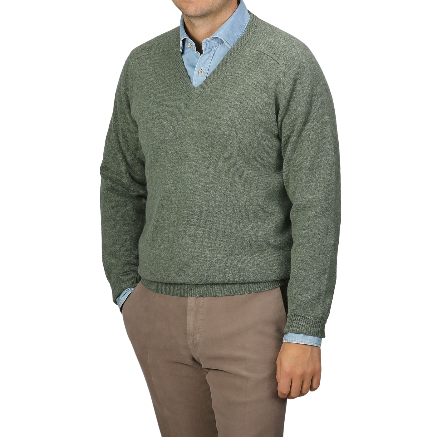 A person is wearing an Alan Paine Landscape Green Lambswool V-Neck sweater over a light blue collared shirt, paired with beige pants. The individual's face is not shown in the image.