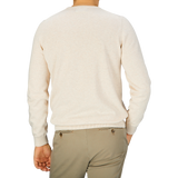The back view of a man wearing an Alan Paine Light Beige Luxury Cotton Crewneck sweater and tan pants.
