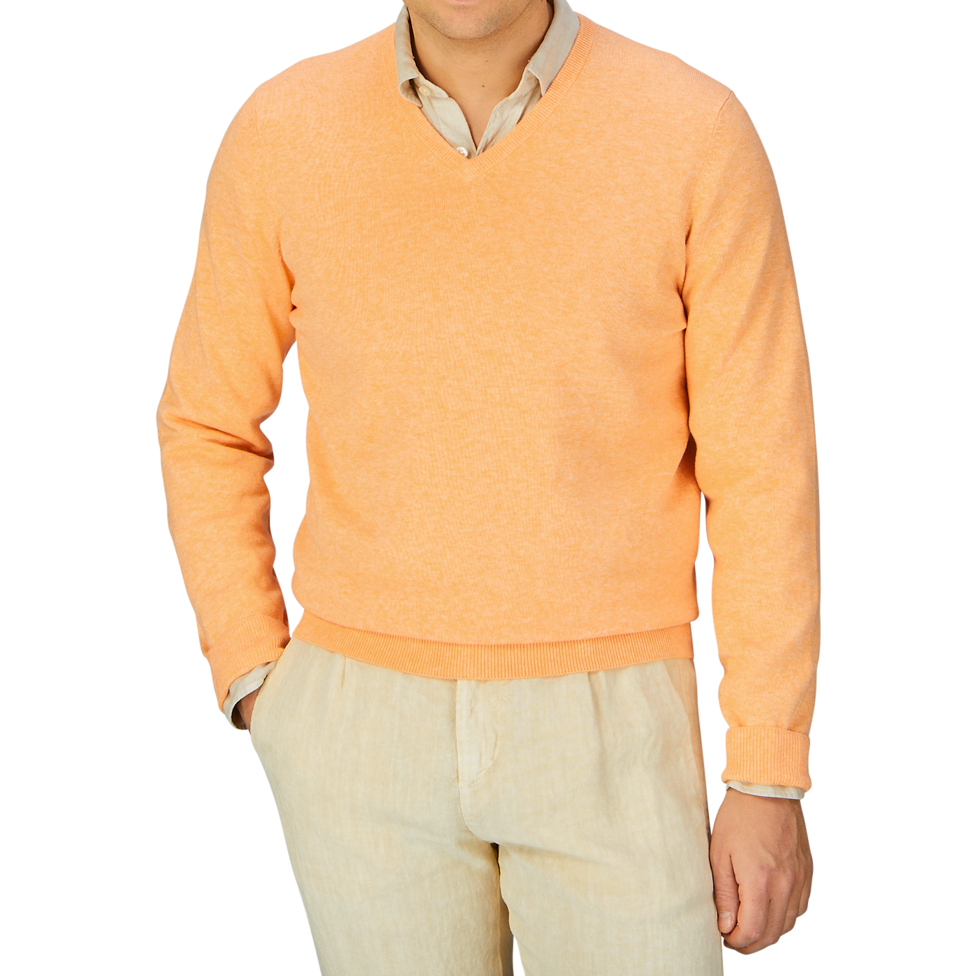 Man wearing an Alan Paine mango orange luxury cotton v-neck sweater over a light shirt with beige pants.
