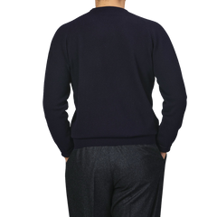 A person wearing an Alan Paine Navy Blue Lambswool Crew Neck and gray pants is photographed from the back against a light gray background.